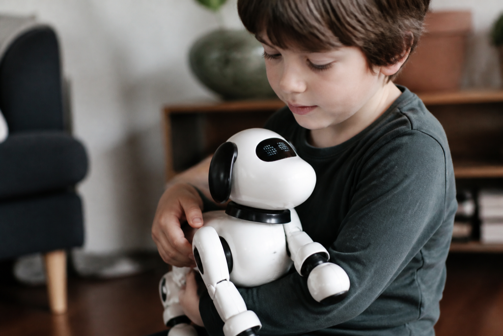 Enfant tient petit robot chien blanc