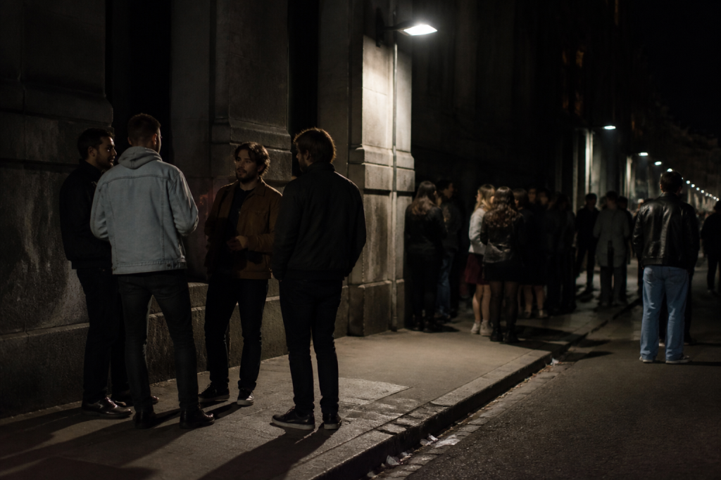 Gens dehors nuit rue urbaine immeuble sombre