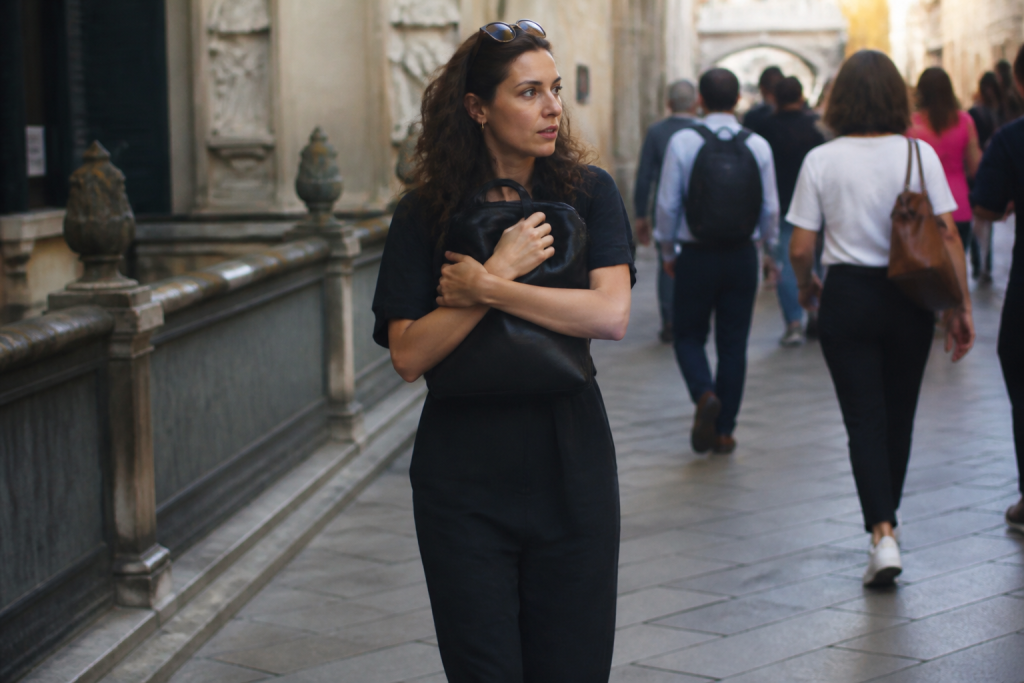 Passant vigilant serrant son sac dans rue touristique