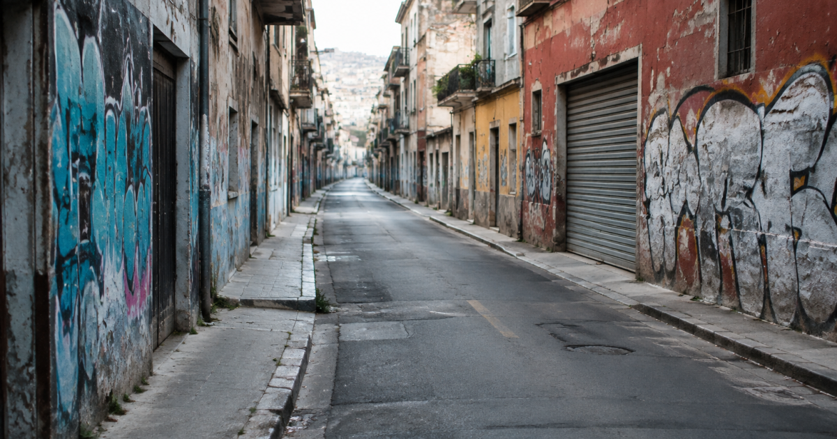 Rue urbaine vide avec facades degradees et graffitis